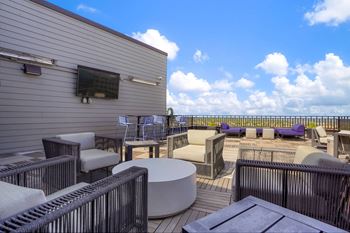 a large patio with chairs and tables on a roof